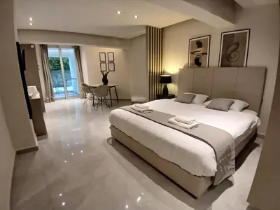 a bedroom with a large white bed and a table at Georgiana Suites in Larnaka