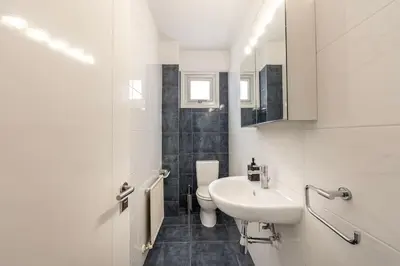 a white bathroom with a sink and a toilet at Luxurious Bright & Stylish 2BR with Office in Nicosia in Nicosia