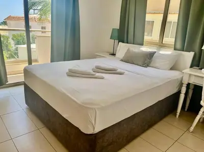 a large bed with towels on it in a bedroom at Eliza Suite at Pernera Beach in Protaras