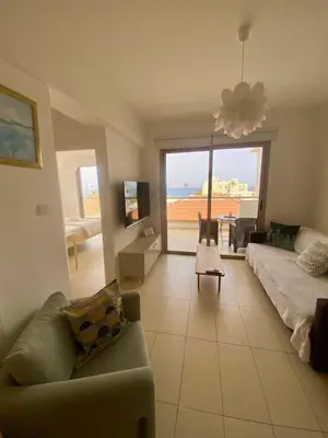 a living room with a couch and a view of the ocean at Aphrodite Sea View Suite in Protaras