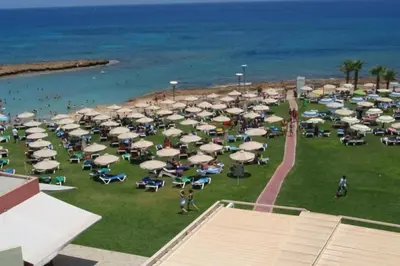 a group of chairs and umbrellas on a beach at Aphrodite Sea View Suite in Protaras