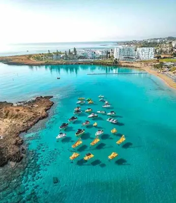 a group of boats in the water next to a beach at 13 Crystal Lagoon Villa in Paralimni