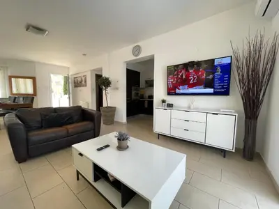 a living room with a couch and a tv on the wall at 13 Crystal Lagoon Villa in Paralimni