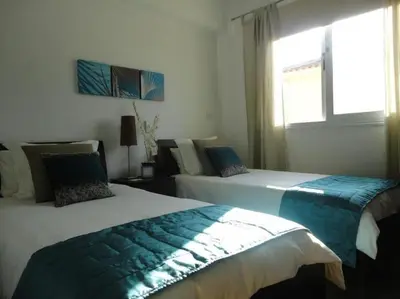 two beds in a white room with a window at 13 Crystal Lagoon Villa in Paralimni