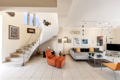 a living room with a staircase and a couch at Chelidonia Larnaca Seafront Villa in Meneou