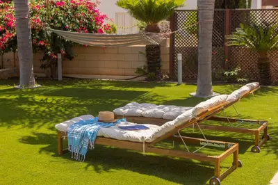 a bed sitting on the grass in a yard at Chelidonia Larnaca Seafront Villa in Meneou