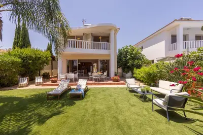 a house with a yard with chairs and tables at Chelidonia Larnaca Seafront Villa in Meneou