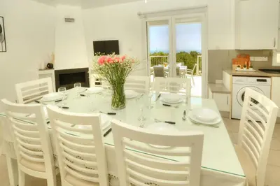 a white dining room with a white table and white chairs at Villa Christina in Ayia Napa