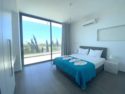 a bedroom with a bed and a large window at NISSI PEARL Holiday Villas Ayia Napa in Ayia Napa