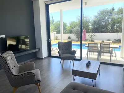 a living room with a couch and chairs and a table at NISSI PEARL Holiday Villas Ayia Napa in Ayia Napa