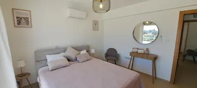 a bedroom with a bed with a pink blanket and a mirror at Nissi 3 Pool View 2 Bedroom Apartment with Large Veranda in Ayia Napa