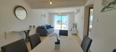 a living room with a table and a couch at Nissi 3 Pool View 2 Bedroom Apartment with Large Veranda in Ayia Napa