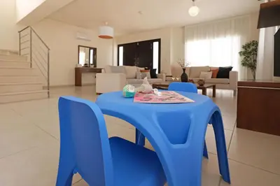 a blue table and chairs in a living room at Villa Artemis - 30m from Pernera Beach in Protaras