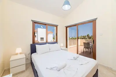 a bedroom with a large bed and a balcony at Villa Sarah in Ayia Napa
