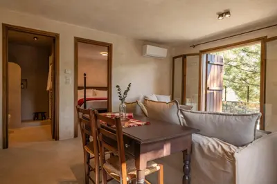 a dining room with a table and a couch at Casa Oliva Guesthouse in Tris Elies