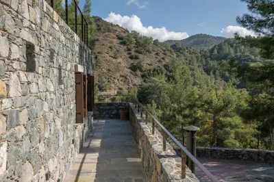 a stone wall with a walkway next to a mountain at Casa Oliva Guesthouse in Tris Elies