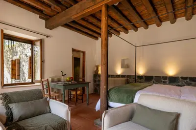 a bedroom with a bed and a table and chairs at Casa Oliva Guesthouse in Tris Elies