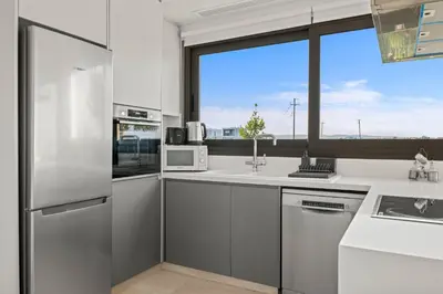 a kitchen with white appliances and a large window at Serenity Waves Villa 12 in Sophtadhes
