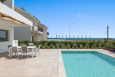 a patio with a table and chairs and a swimming pool at Serenity Waves Villa 16 in Larnaka
