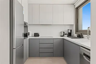 a white kitchen with white cabinets and a sink at Serenity Waves Villa 16 in Larnaka