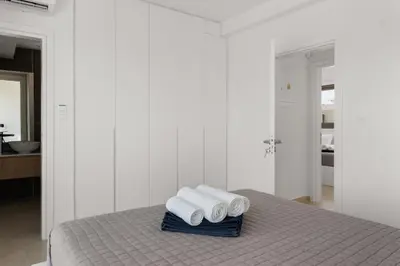 a white room with a bed with three rolled towels at Serenity Waves Villa 17 in Larnaka