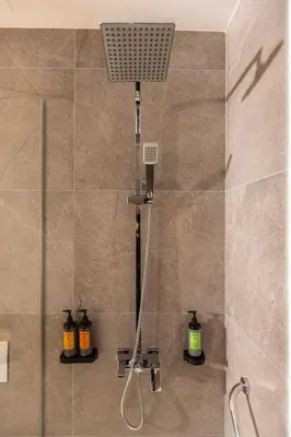 a shower in a bathroom with a shower head at Shanti Tranquil Escapes in Paralimni