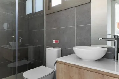 a bathroom with a white sink and a toilet at Serenity Waves Villa 26 in Larnaka