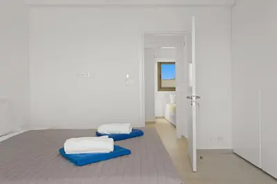 a white room with two beds and a mirror at Serenity Waves Villa 26 in Larnaka