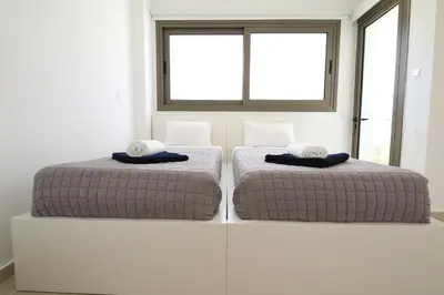 two beds sitting next to each other in a room at Serenity Waves Villa 27 in Sophtadhes