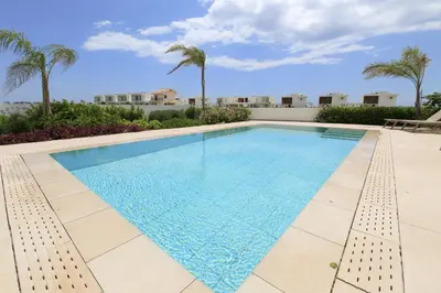 a swimming pool with palm trees in the background at Serenity Waves Villa 27 in Sophtadhes