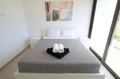 a bedroom with a bed with two white shoes on it at Serenity Waves Villa 27 in Sophtadhes