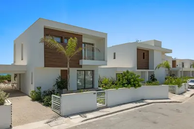 a white house with a palm tree in front of it at Serenity Waves Villa 7 in Sophtadhes
