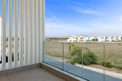 a balcony with a view of a field and houses at Serenity Waves Villa 4 in Sophtadhes