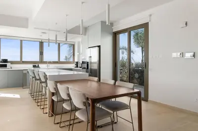 a kitchen with a wooden table and chairs at Serenity Waves Villa 4 in Sophtadhes