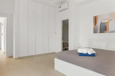 a white bedroom with a bed and white cabinets at Serenity Waves Villa 4 in Sophtadhes
