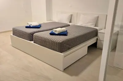 two beds with towels on top of them in a room at Serenity Waves Villa 4 in Sophtadhes