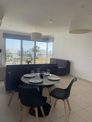 a living room with a table and chairs and a couch at Fig Tree View Apartments in Protaras