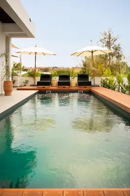 a swimming pool with two chairs and umbrellas at Amazing Protaras Villa Villa Lubbock 3 Bedrooms Private Outdoor Pool in Protaras
