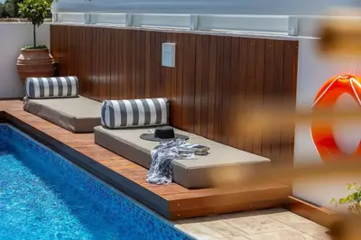 two beds sitting next to a swimming pool at Extraordinary Protaras Villa Villa Leone 3 Bedrooms Private Outdoor Pool in Protaras
