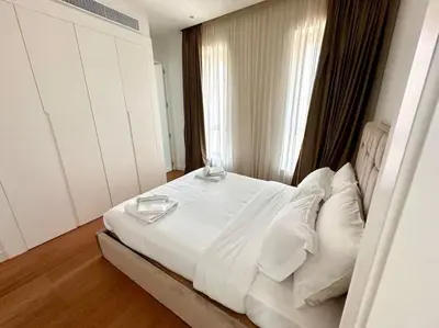 a bedroom with a white bed with two glasses on it at Del Mar Beachfront 3 Bedroom 'A' Residence in Limassol