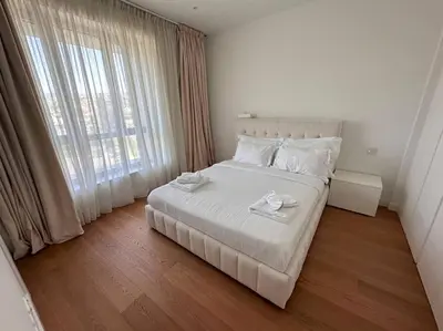 a bedroom with a white bed and a large window at Del Mar Beachfront 3 Bedroom 'A' Residence in Limassol