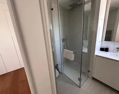 a bathroom with a glass shower and a sink at Del Mar Beachfront 3 Bedroom 'A' Residence in Limassol