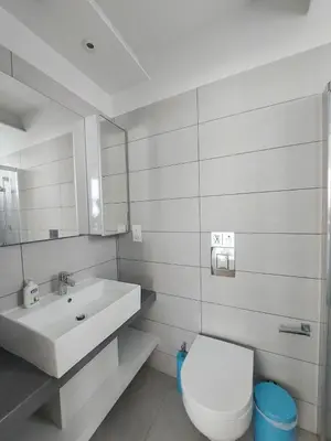 a white bathroom with a sink and a toilet at Mythical Sands - Escape in Paralimni