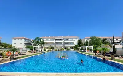 a pool at a resort with people in it at Mythical Sands - Escape in Paralimni