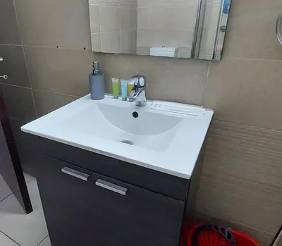 a bathroom with a white sink and a mirror at Paradise by the Sea in Larnaka