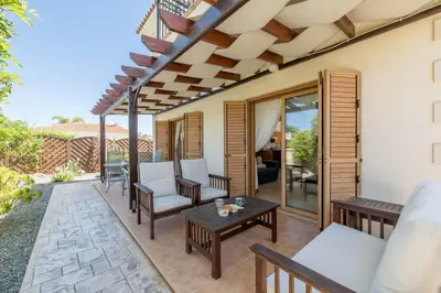 a patio with chairs and a table on a patio at Elena Gardens Villa in Ayia Napa