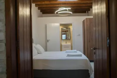 a bedroom with a bed and a mirror in a room at AROMA DRYOS in Kato Drys