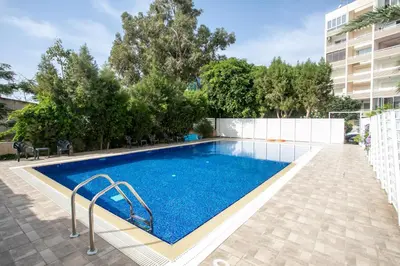 a swimming pool with blue water in a building at Palmove Luxurious Beachfront Apt in Larnaka
