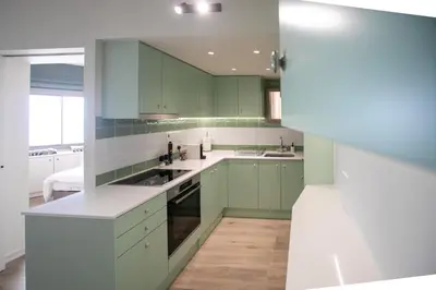 a kitchen with green cabinets and white counter tops at Palmove Luxurious Beachfront Apt in Larnaka