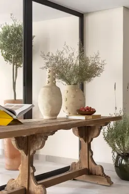 a mirror on a table with two vases on it at White City Limassol in Limassol